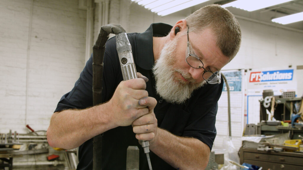 Anderson employee using tool in shop