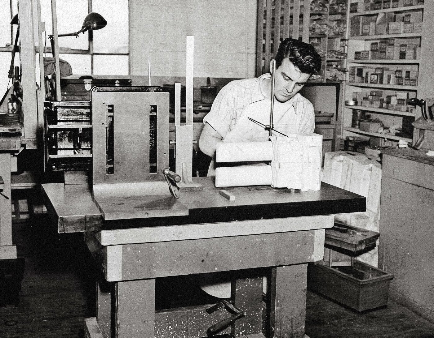 A young Anderson Pattern craftsman working with patterns at his bench