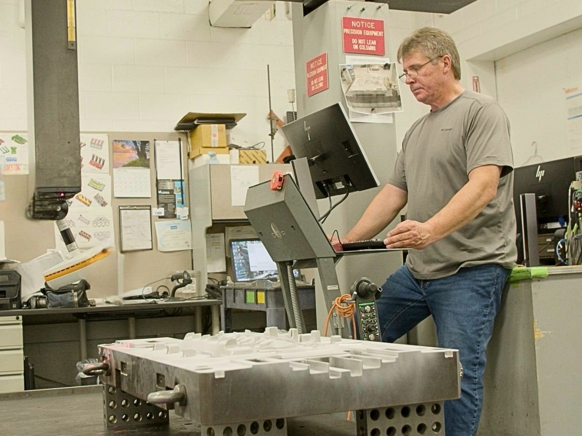 Anderson Global craftsman inspecting precision tooling on a CMM coordinate measuring machine